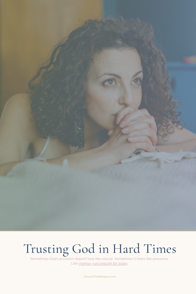 A woman praying and trusting God in hard times. She's kneeling at her bed in her bedroom staring up into the sky, hands folded and praying. 