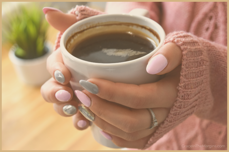 Woman's hands wrapped around a warm coffee cup in a dusty rose sweater - GraceInTheMargins.com